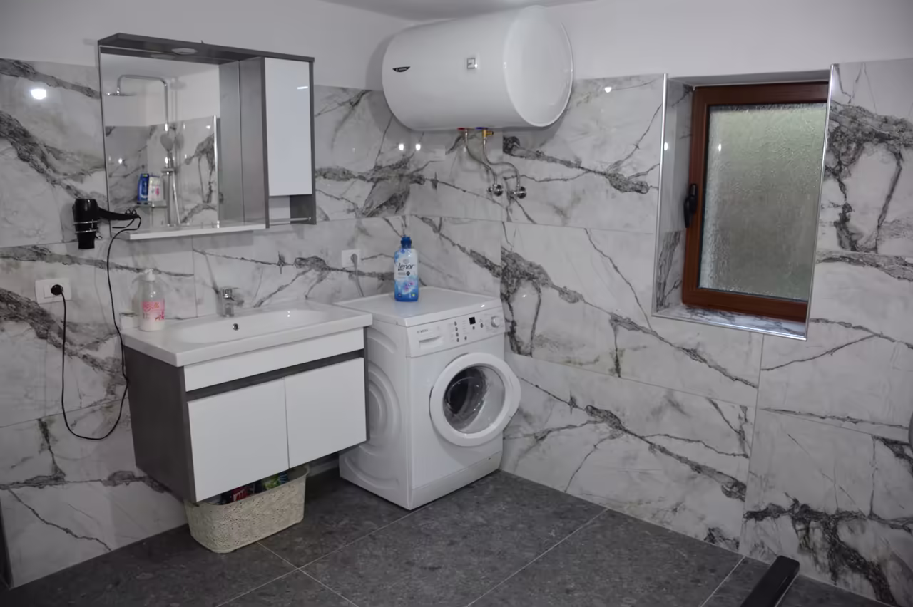 Bathroom with a washbasin, a mirror cabinet, a hairdryer and a washing machine