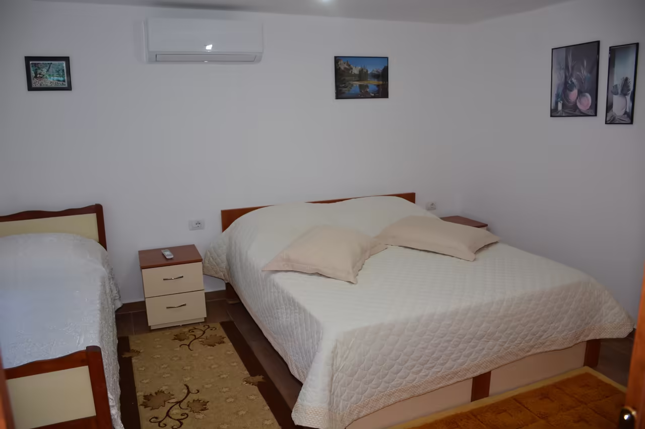 Bedroom with a double bed, a single bed and an air conditioner