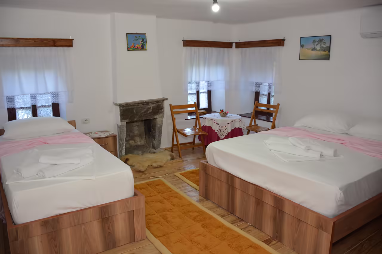 Bedroom with a double bed, a single bed and a stone fireplace