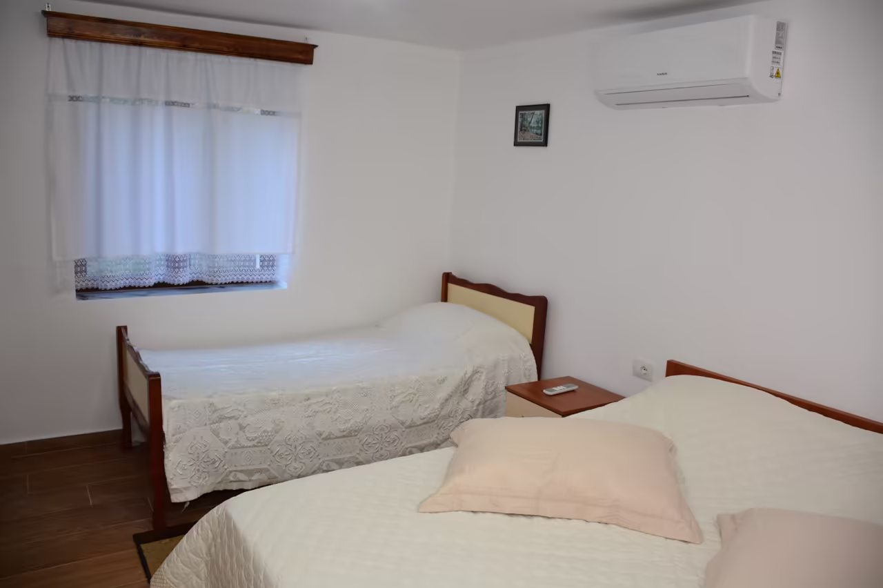 Room with a single bed, a double bed and an air conditioner