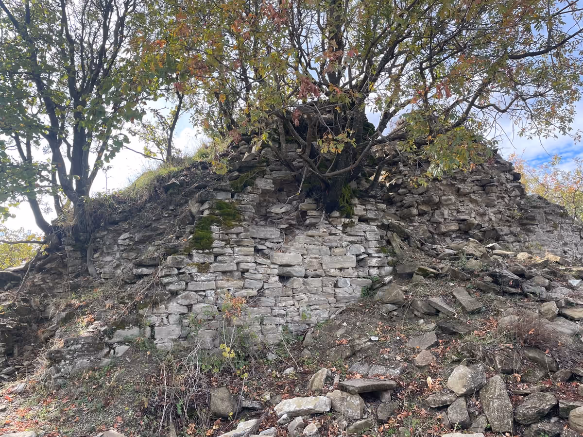 Old castle walls at the highest point of the hike, built of dry stone with trees growing out of the top