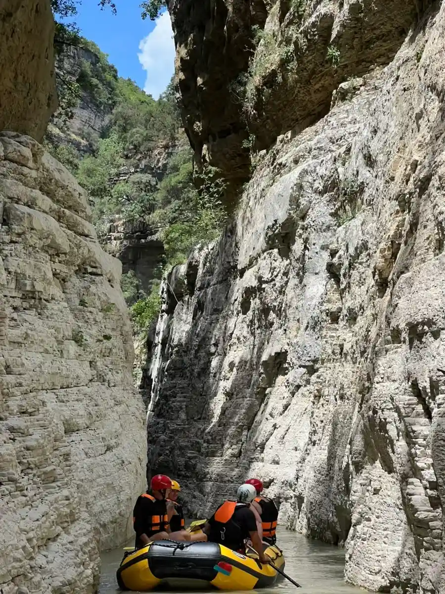 Dramatic rock overhang above a small raft in Osum Canyon
