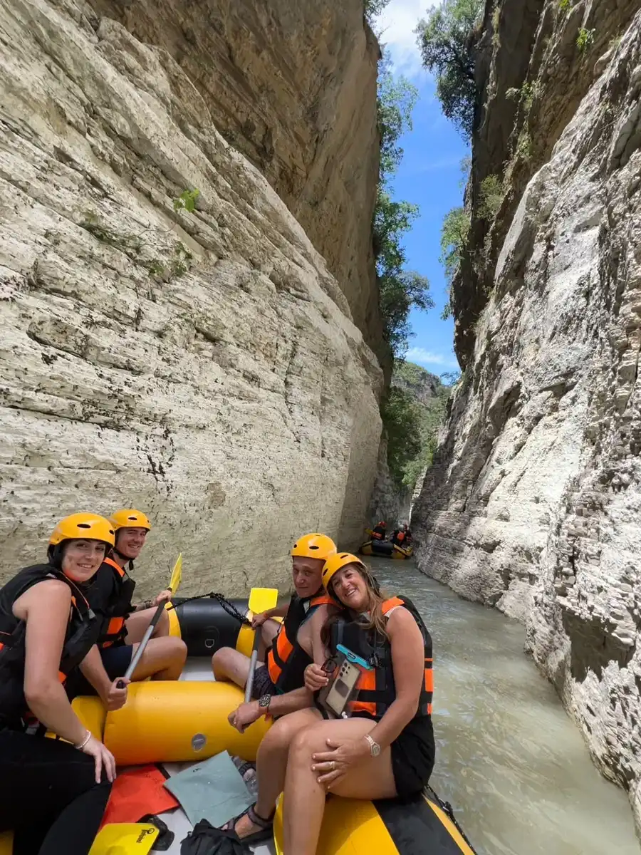 Four paddlers pause in the narrow white limestone gorge of Osum Canyon