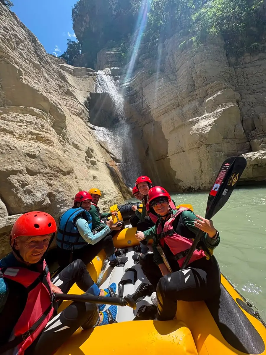 Rafters pausing beneath a waterfall pouring into Osum Canyon