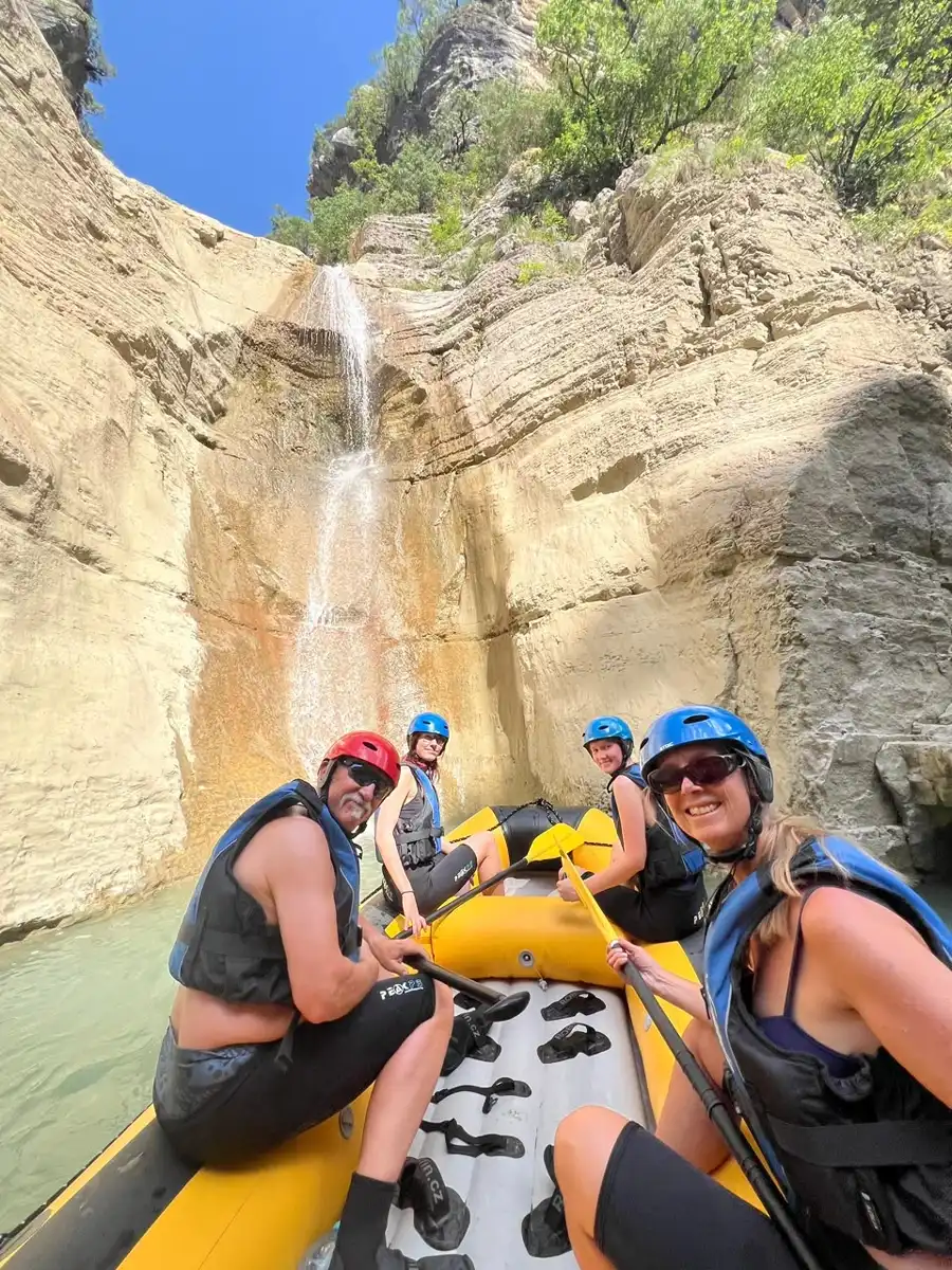 Rafters resting at the base of a tall waterfall in Osum Canyon