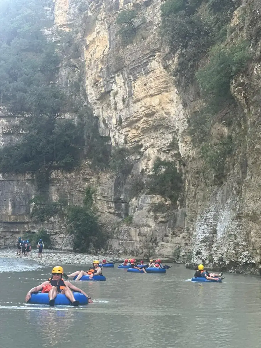 Tubers floating individually along a calm stretch of the Osum River
